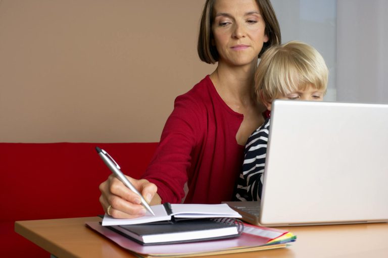 woman in red long sleeve shirt writing on her notebook